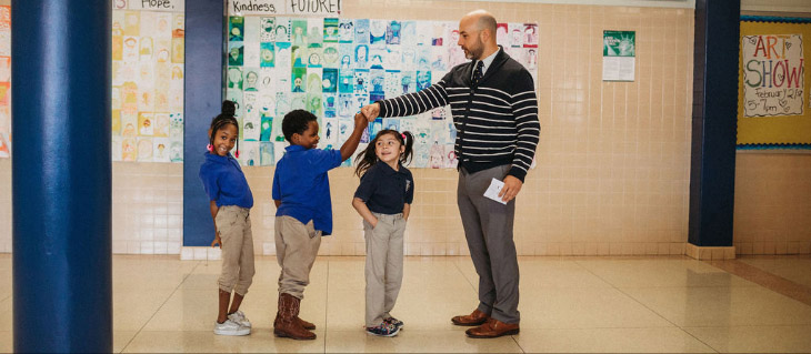 teacher with students in a hallway